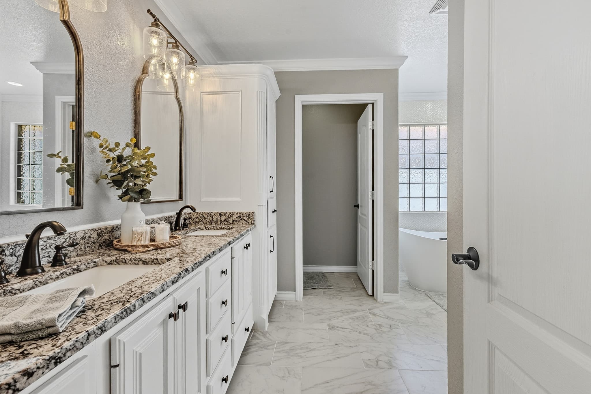 HDR interior photograph of a Lubbock master bathroom with balanced window light and warm fixtures